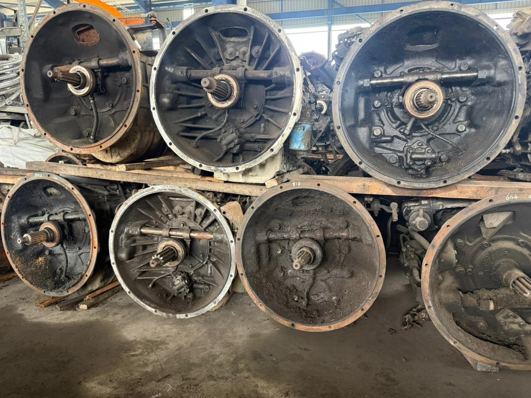 Stacked heavy-duty transmission and differential housings across the yard.